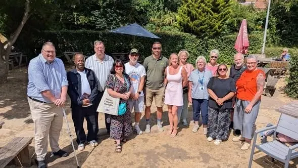 A group of local business owners standing together in a sunny pub garden at a Business and Brew networking event