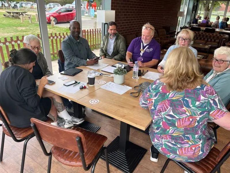 Volunteers and residents around tables at the John Clements Sports and Community Centre in Codicote, working on phones and paperwork together