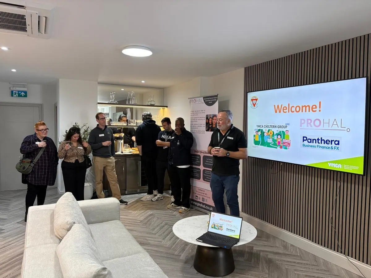 Guests with coffee at the Corporate Connect Club Network and Learn event, gathered by a screen reading Welcome with the YMCA Chiltern Group, ProHal and Panthera logos
